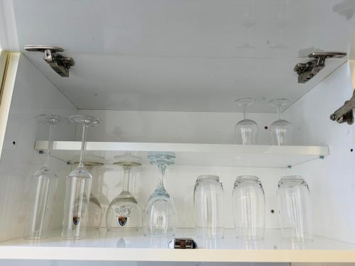 a bunch of glassases are sitting on a shelf at Appartement Premium à Liège in Liège