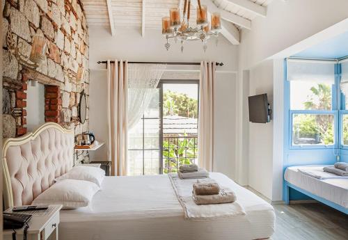 a bedroom with a large white bed and a brick wall at Bellezza Hotel Alaçatı in Alaçatı