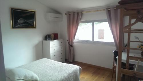 a bedroom with a bed and a window at Chambre d'hôtes à Juvignac in Juvignac