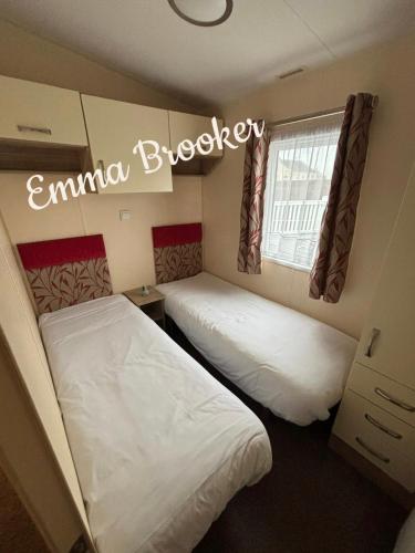 two beds in a small room with a window at Lapwing 32 Cayton Bay in Scarborough
