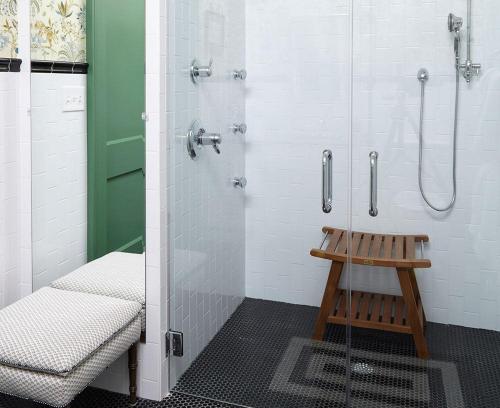 a bathroom with a shower and a wooden stool at Pandora's Manor in High Point