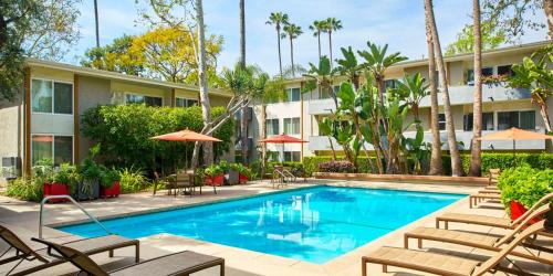 a pool at a hotel with chairs and umbrellas at West LA Boutique Apartments Minutes from the Coast in Los Angeles
