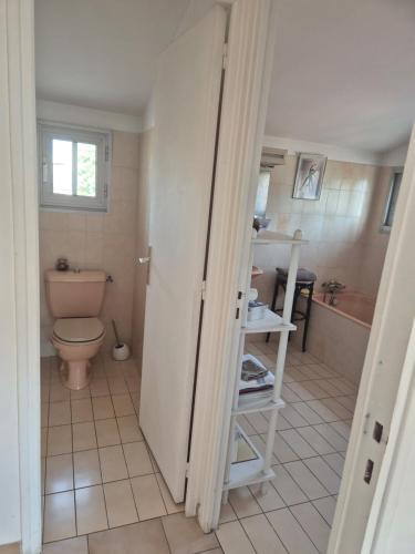 a bathroom with a toilet and a sink and a tub at Chambre d'hôtes à Juvignac in Juvignac
