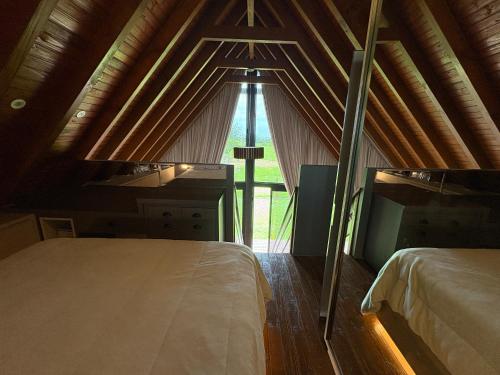 a room with a bed and a large window at Chalé Rústico com Piscina Aquecida e Hidro in Araranguá