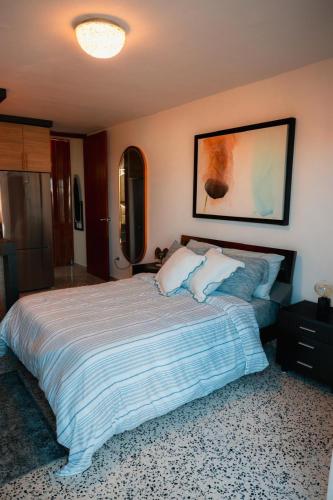 a bedroom with a large bed and a painting on the wall at La Posadita in Carolina