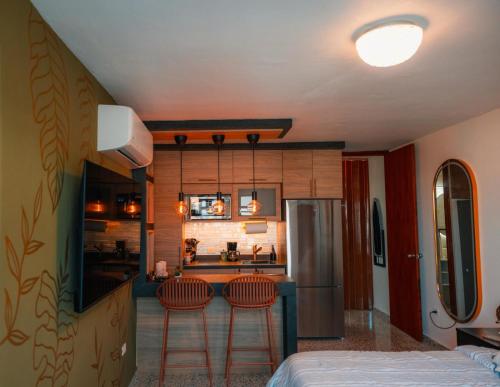 a kitchen with two bar stools and a refrigerator at La Posadita in Carolina