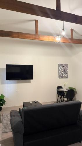 un soggiorno con un divano nero e un tavolo di ELY's Modern Studio Apartment a Paramaribo