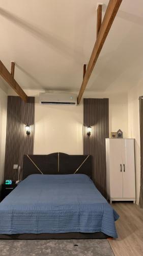 una camera da letto con un letto blu e un armadio bianco di ELY's Modern Studio Apartment a Paramaribo