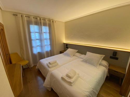 a bedroom with two beds with towels on them at Hostal Restaurante Casa Santamaria in Doneztebe