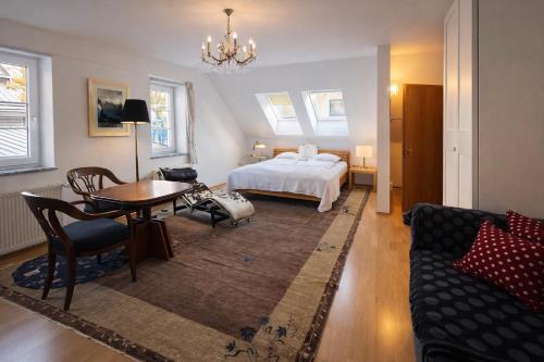 a bedroom with a bed and a table and a couch at Schlossapartments Wolfsberg in Wolfsberg