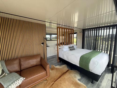 a bedroom with a bed and a couch at Ultimate Vineyard Escape - Waipara in Waipara