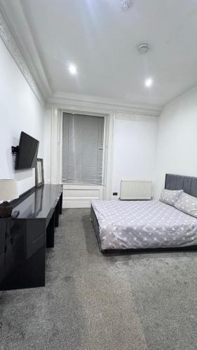 a bedroom with a bed and a desk and a television at Fulwoodroomz in Preston