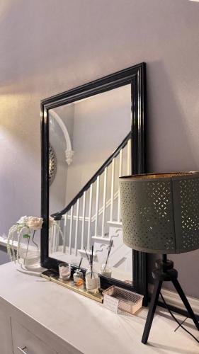 a mirror on top of a dresser with a lamp at Fulwoodroomz in Preston
