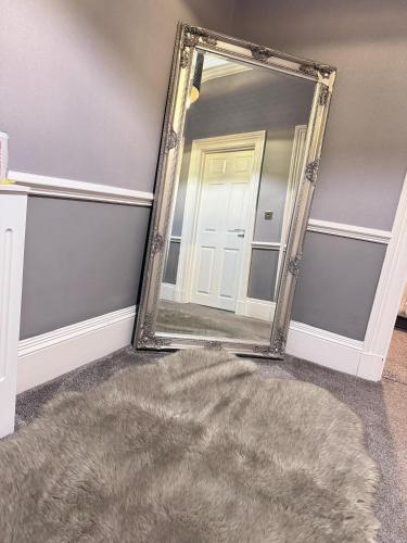 a mirror in a room with a rug and a door at Fulwoodroomz in Preston