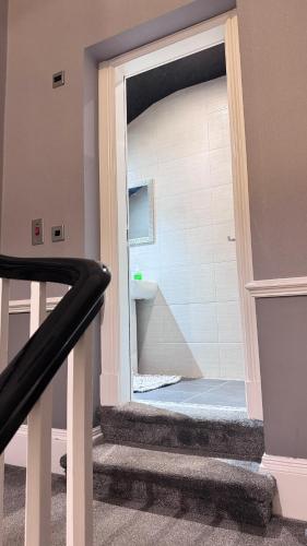 a staircase with a door open to a bathroom at Fulwoodroomz in Preston