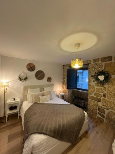 a bedroom with a bed and a stone wall at Senhora da Estrela AL in Seia