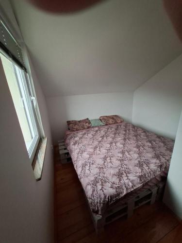 a small bed in a small bedroom with a window at Nature escape Sarajevo in Kasatići