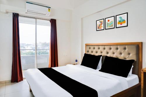 a bedroom with a large bed and a window at Super Townhouse Lohegaon Near Pune Airport Formerly Landmark Regency in Pune