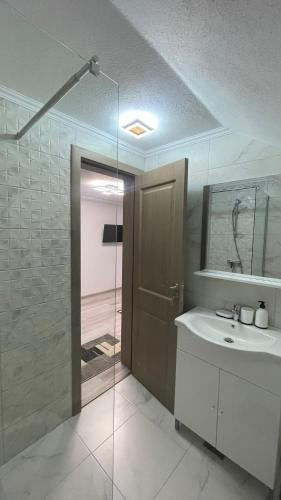 ein Badezimmer mit Dusche, Waschbecken und Spiegel in der Unterkunft Silent Hills in Moieciu de Jos