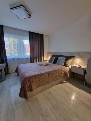 a bedroom with a bed and a large window at Angel in Kołobrzeg