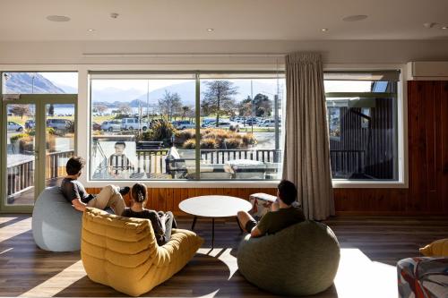 a group of people sitting in chairs in a living room at Haka House Wanaka in Wanaka