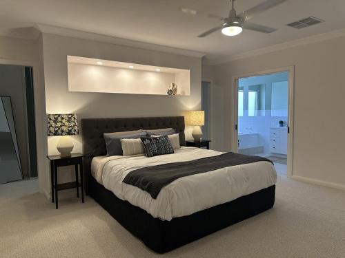 a bedroom with a large bed and two lamps at Solara Retreat Mildura in Mildura