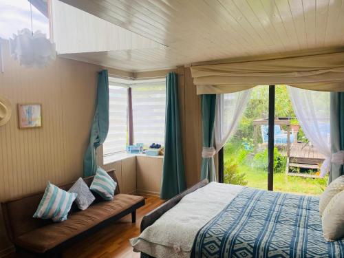 a bedroom with a bed and a large window at La Casona del Trancura in Pucón