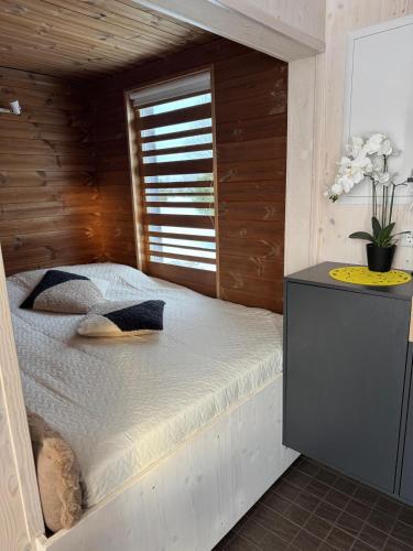 a bedroom with a bed with a wooden wall at EstBerg Tartu Glasshouse with Sauna in Tartu