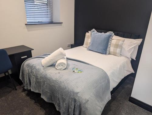 a bedroom with a bed with towels and a desk at Central Swansea 6BR Ensuite Home w Parking in Swansea