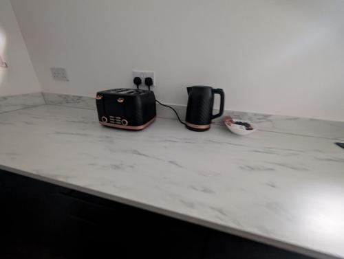 a counter top with two coffee makers on it at Central Swansea 6BR Ensuite Home w Parking in Swansea