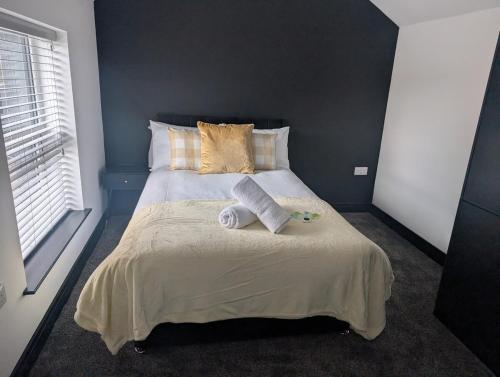 a bedroom with a bed with two towels on it at Central Swansea 6BR Ensuite Home w Parking in Swansea
