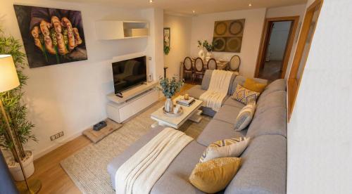 a living room with a couch and a television at Apartalux Playa Diva in Grao de Castellón
