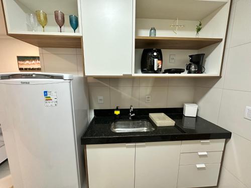 a small kitchen with a sink and a refrigerator at Mana Beach Experience in Ipojuca
