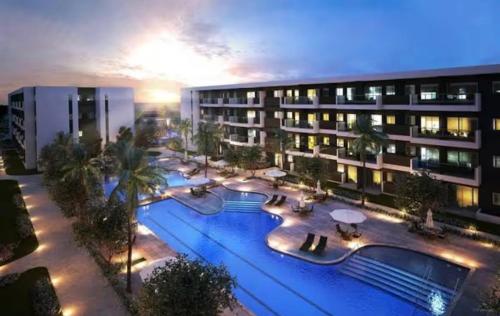 a large building with a swimming pool at night at Mana Beach Experience in Ipojuca