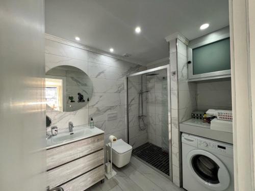 a bathroom with a sink and a washing machine at Toni LuXx Suite Monte Golf in Mogán