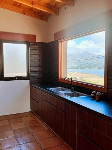 a kitchen with a sink and two windows at CasaVid - Private Boutique Chalet & Spa - Vistas 360 in Tafí del Valle