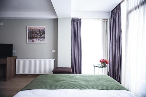 a bedroom with a bed and a large window at Bakuriani - Didveli Gallery B212 in Bakuriani