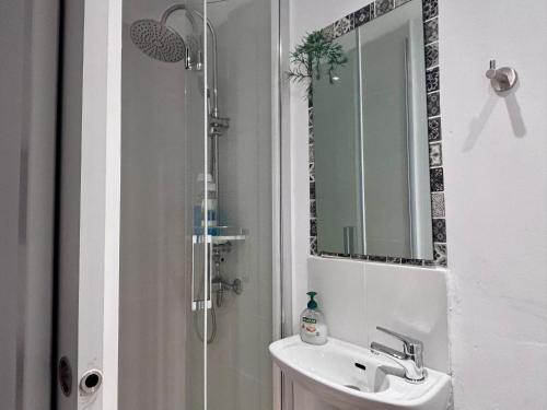 a bathroom with a sink and a shower with a mirror at Bodeguita del Tiétar in Pedro Bernardo