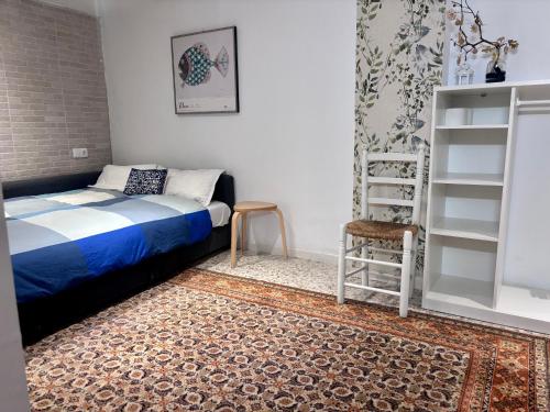 a bedroom with a bed and a ladder and a chair at Bodeguita del Tiétar in Pedro Bernardo
