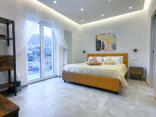a bedroom with a bed and a large window at Delphi Soggiorni Romantic Suites with Private Terrace - Ischia Porto in Ischia Town