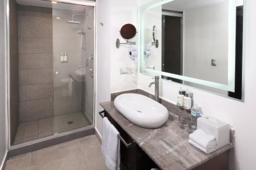 a bathroom with a sink and a shower at Garner Hotel Mazatlan Beach by IHG in Mazatlán