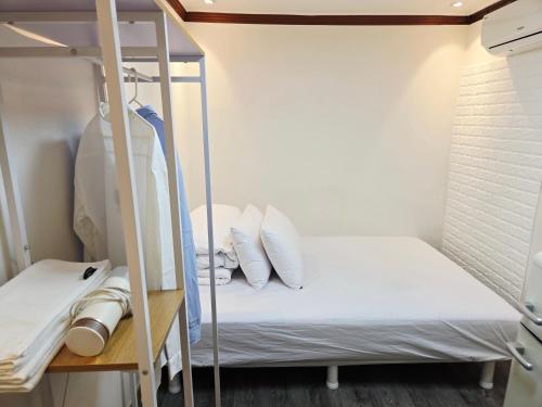 a bunk bed with white pillows and a ladder at URBAN KS Stay in Seoul