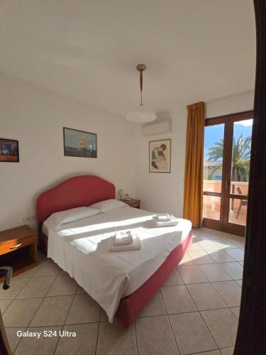 a bedroom with a large bed with a red headboard at Appartamento A Limone in Limone sul Garda