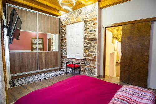 a bedroom with a large red bed and a tv at Mary's cozy apartment 2 in Pýrgos