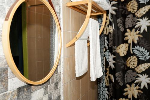a bathroom with a round mirror and towels at Résidence-PKLV in Dzaoudzi
