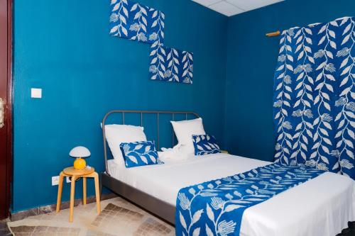 a blue room with two beds and a table at Résidence-PKLV in Dzaoudzi