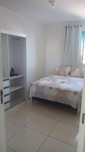 a white bedroom with a bed and a window at Apto mobiliado 7min da Orla de Atalaia e 1min do Aeroporto in Aracaju