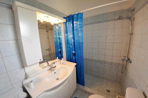 a bathroom with a sink and a toilet and a mirror at Corfu Villa Ermioli with Pool in Giannádes