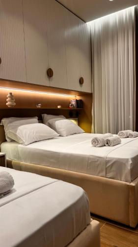 two beds in a hotel room with white sheets at Luxurios seaside apartment 2 in Durrës