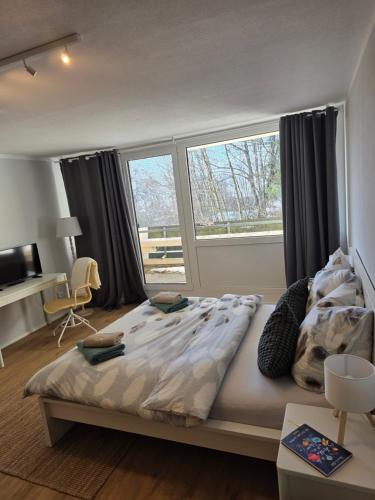 a bedroom with a large bed and a window at Waldfeder Apartment mit Pool und Fitnessraum, neu und vollsaniert in Sankt Englmar
